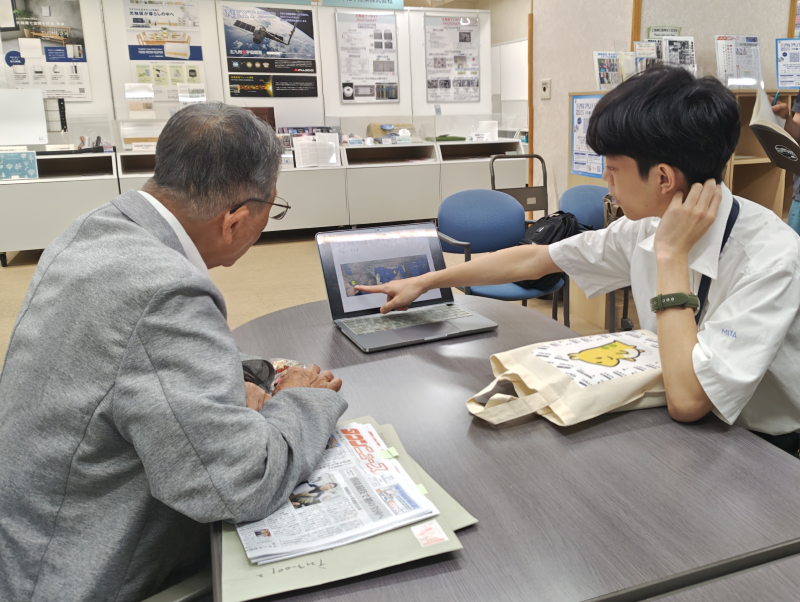 藤嶋先生へ早田さんが動画を見ながら報告をする様子の写真