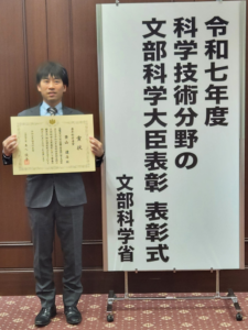 授賞式で賞状と撮影する景山研究員の写真